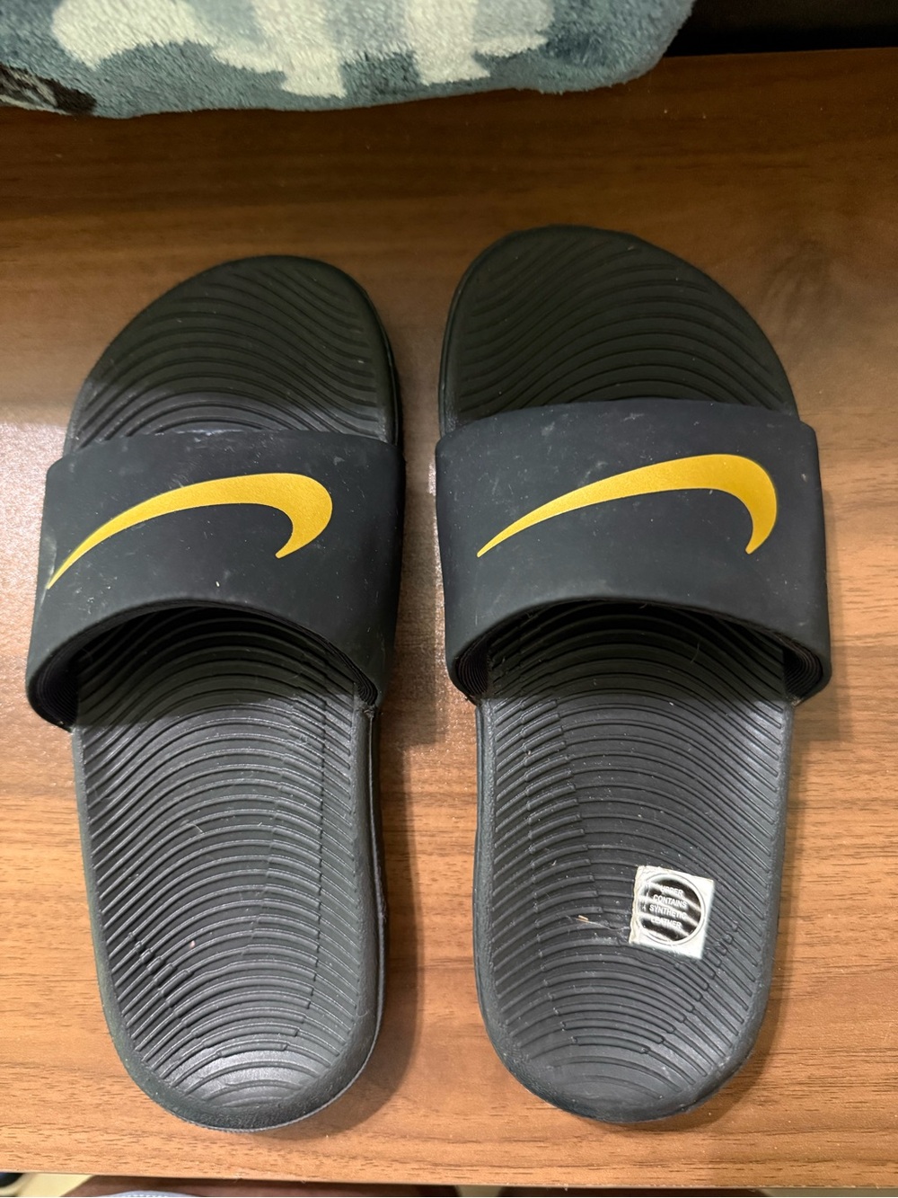 Nike Black Slides with Gold Swoosh Accent